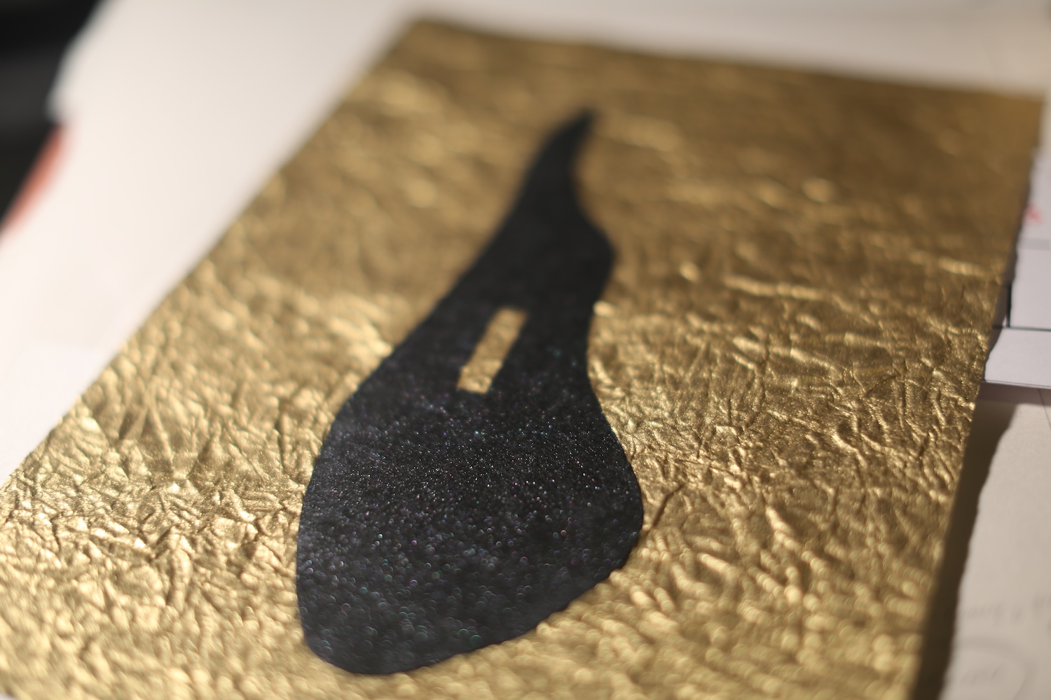 A cut-paper enso layered over gold foil